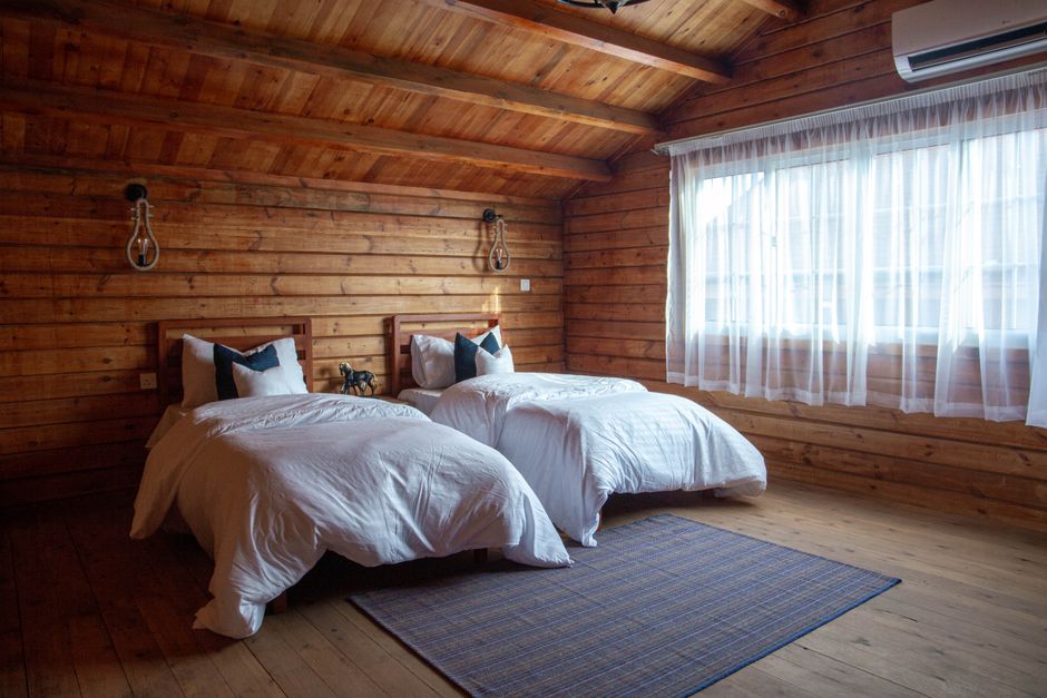 Rustic log cabin bedroom with warm wood walls and twin beds